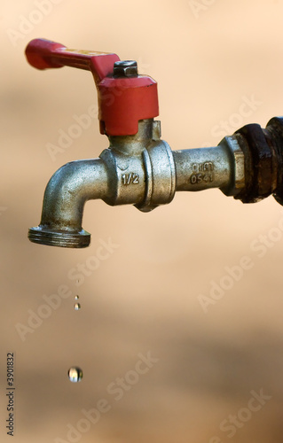 Image shows a tap dripping water against a dry background