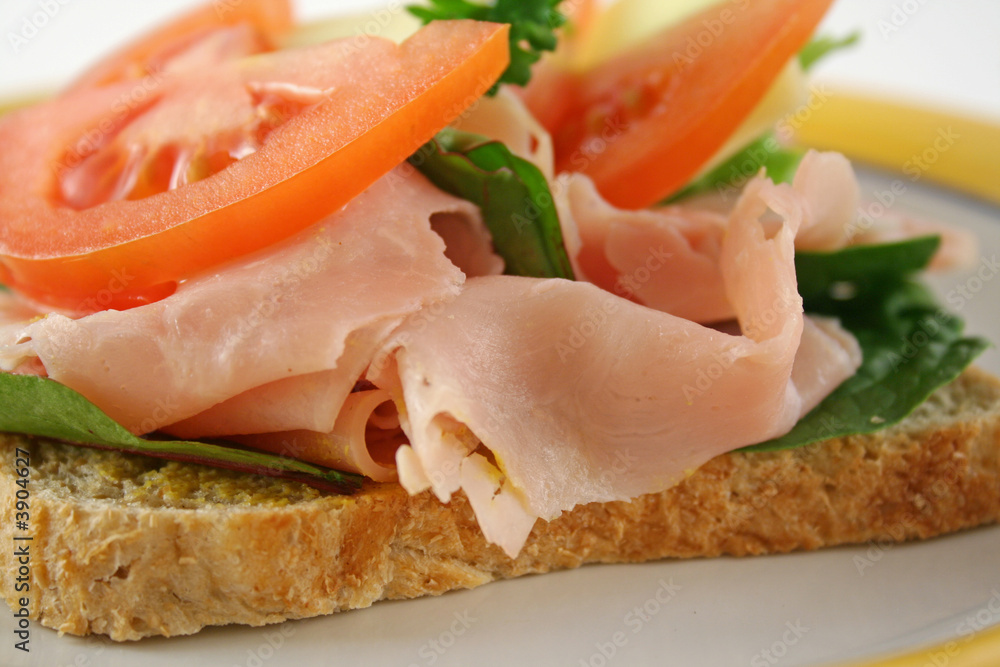 Ham lettuce tomato and cheese open sandwich on wholemeal bread. Ham lettuce tomato and cheese open sandwich on wholemeal bread.