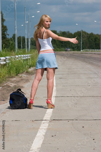 Young woman stopping a car on the road.