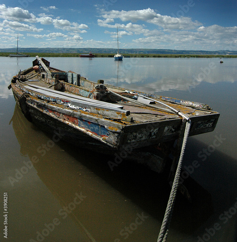 Abandoned boat rising with the tide at Heswall shore photo