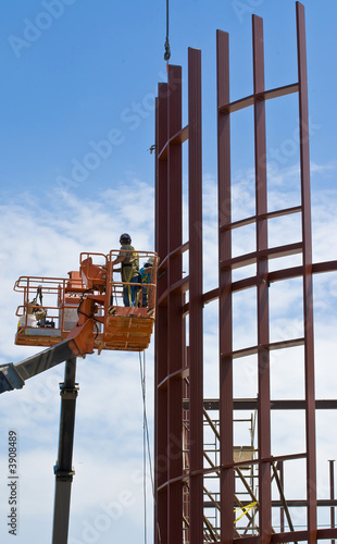 Steel construction workers and cranes