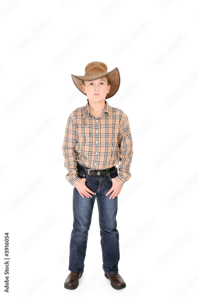 A young cowboy standing with feet apart on a white background.