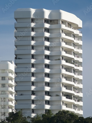 The top floors of white, luxury apartment building.