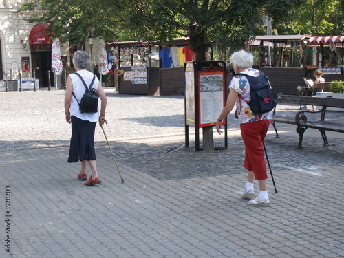 zwei ältere frauen spazieren mit stock durch stadt