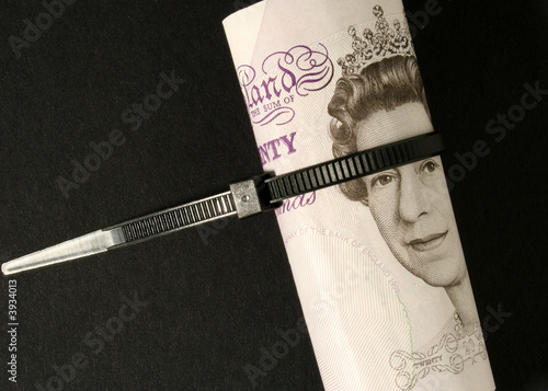 Britsh Pound notes tied with plastic cable strap. photo