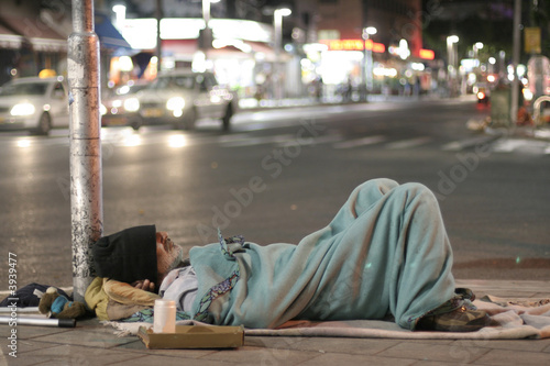 male homeless sleeping in a street photo