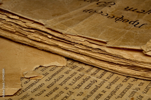 Closeup of an old book with tattered pages and slavonic text