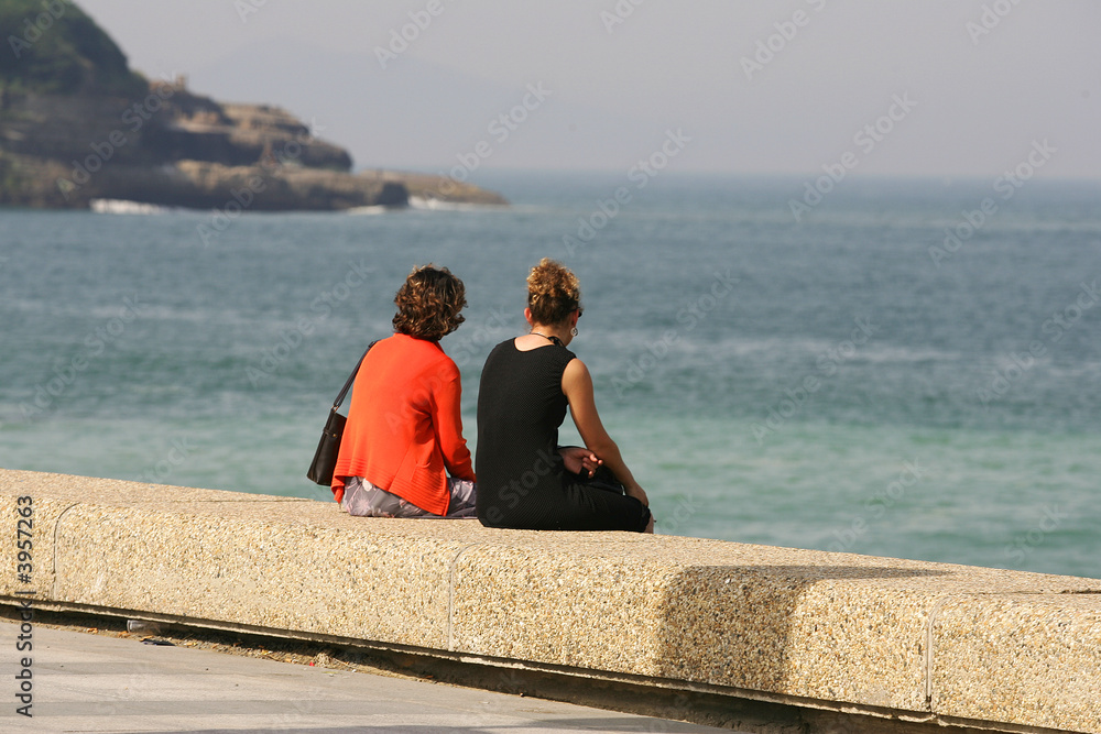 femmes assises en bord de mer