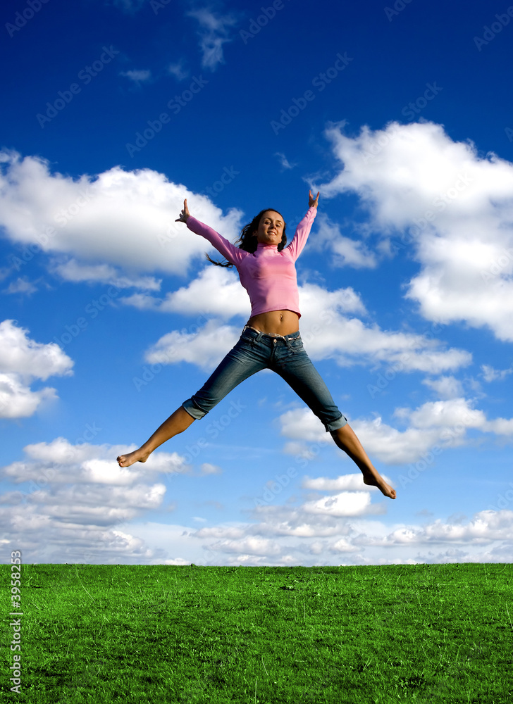 Happy young beautiful girl jumping in the green field. Happy young beautiful girl jumping in the green field.