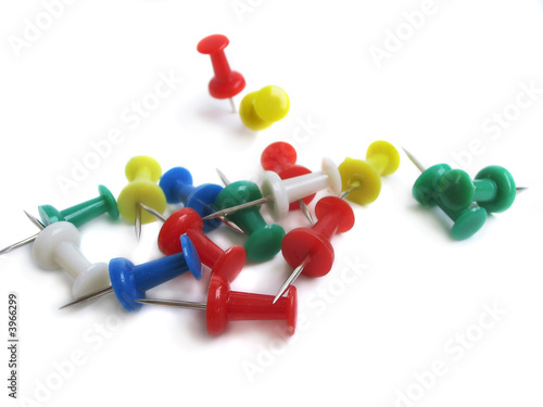 A colourful pile of drawing pins piled on a white background