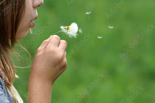 gorl blowing a dandelion