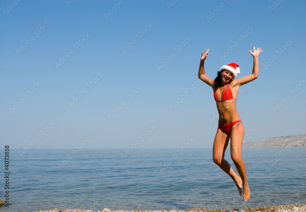 young sexy santa girl is jumping in the beach