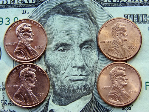 Five Dollar Bill With Pennies Stacked On Top