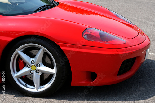 front of red supercar