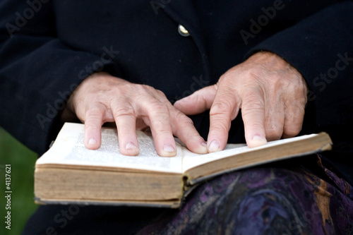 Senior's hands on old Bible