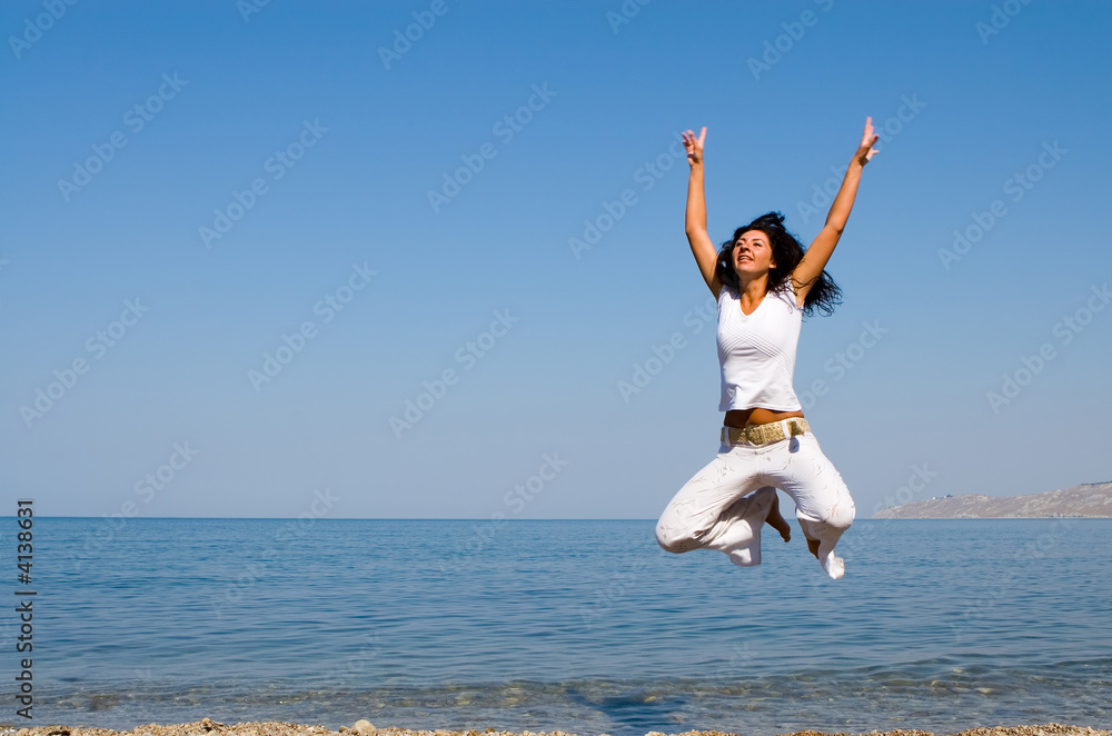 happy young woman is jumping in the beach happy young woman is jumping in the beach