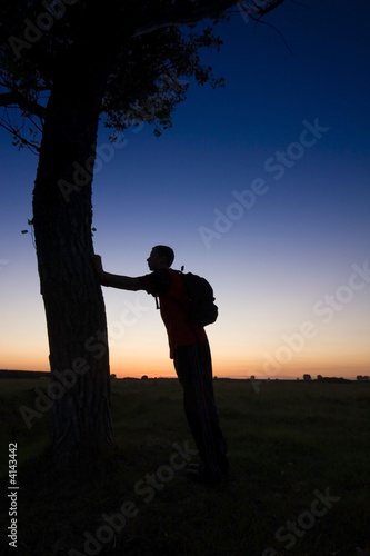 A man's silhouette in the sunset with a tree © Kavita