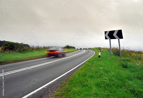Moving car rounds country bend