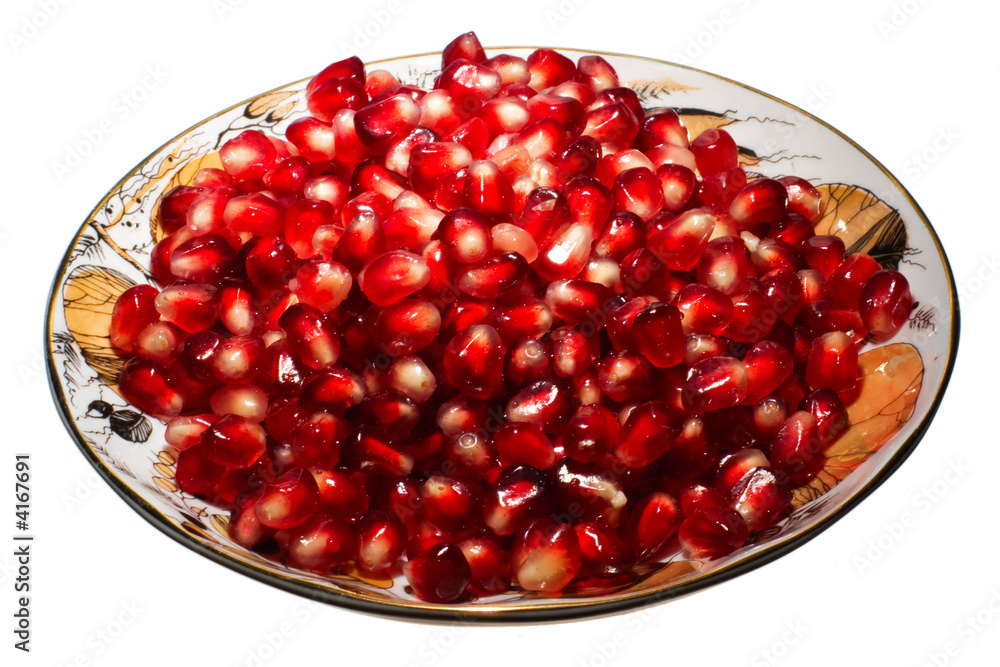 Pomegranate grains on a plate. Isolated on white. Pomegranate grains on a plate. Isolated on white.