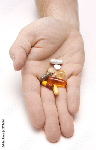 Hand outstretched with a pile of pills