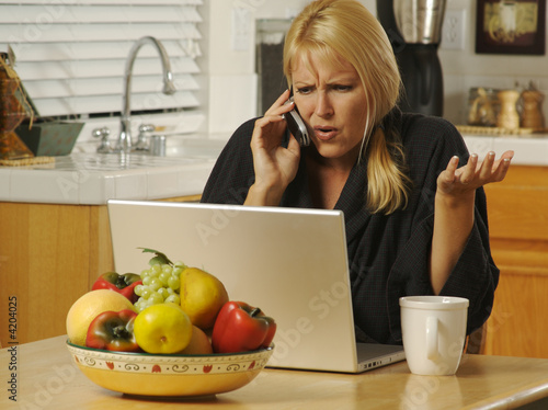 Woman in her kitchen on cel...