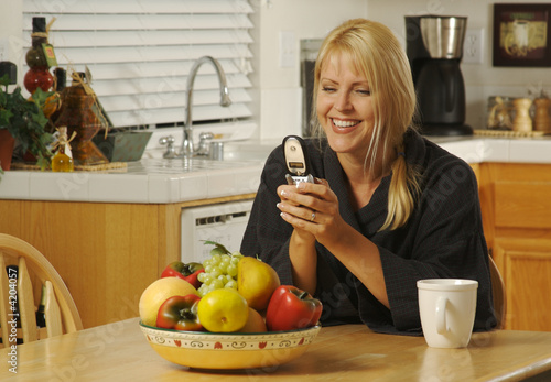 Woman in her kitchen textin...
