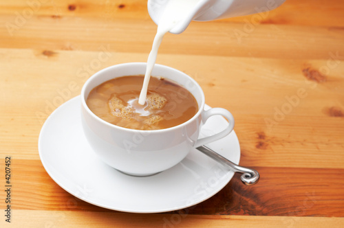 Closeup of milk being poured into the coffee