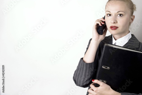 Businesswoman with black binder using a phone