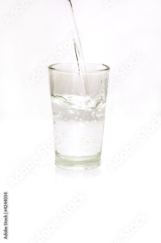 Pouring water on a glass - isolated