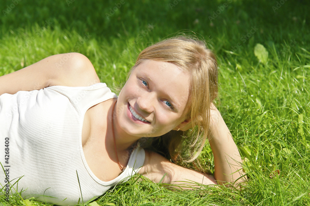 young smiling girl lying on the grass young smiling girl lying on the grass