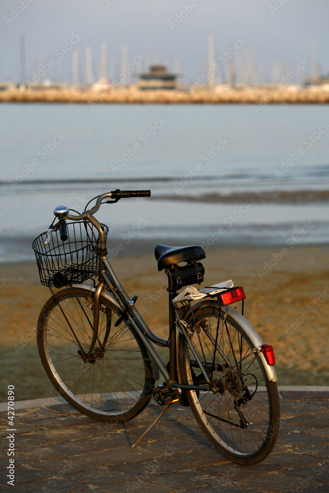Classic bicycle parked on the seafront at sunset Classic bicycle parked on the seafront at sunset