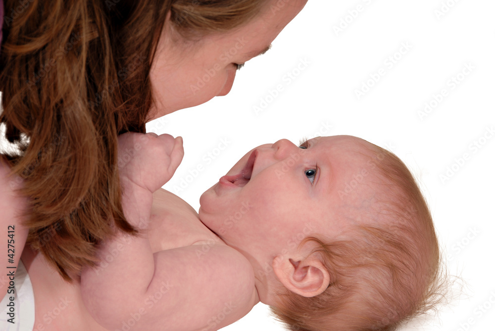 Baby laying on floor observing mother's face over her Baby laying on floor observing mother's face over her