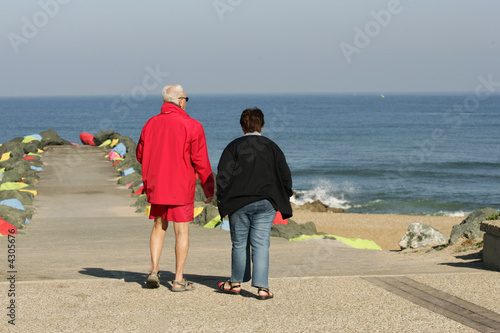 couple de retraités qui marchent en bord de mer