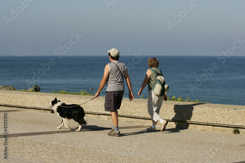couple qui se promène leur chien en laisse