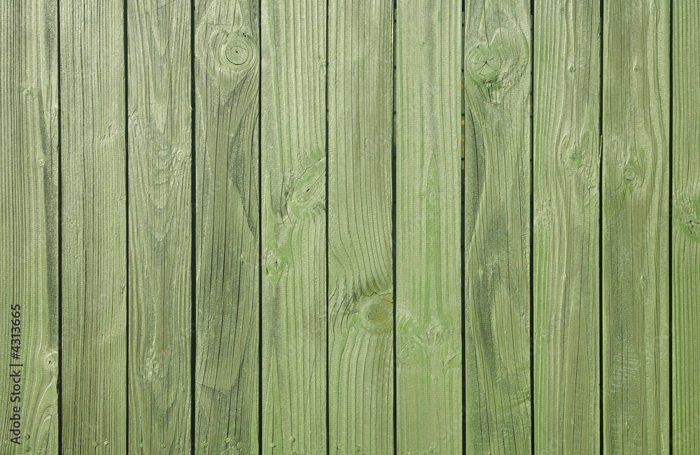 A close up of a green painted wooden fence. A close up of a green painted wooden fence.