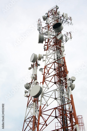 two cellular communication towers on a cloudy day