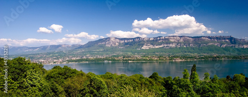 Lac entourré par des collines et des arbres verts.