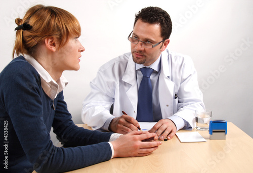 Canvas-taulu Doctor and young woman patient talking to each other.
