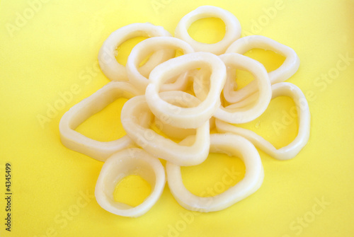 Frozen calamari rings on the yellow background