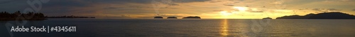 A ultra wide panorama view of a golden sunset ocean