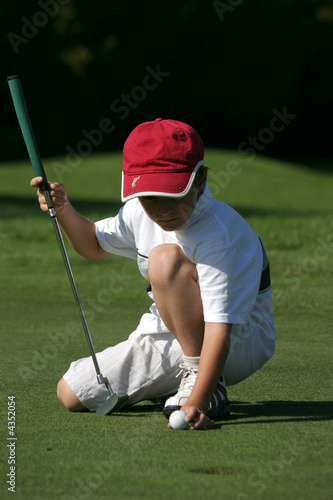 petit golfeur place sa balle