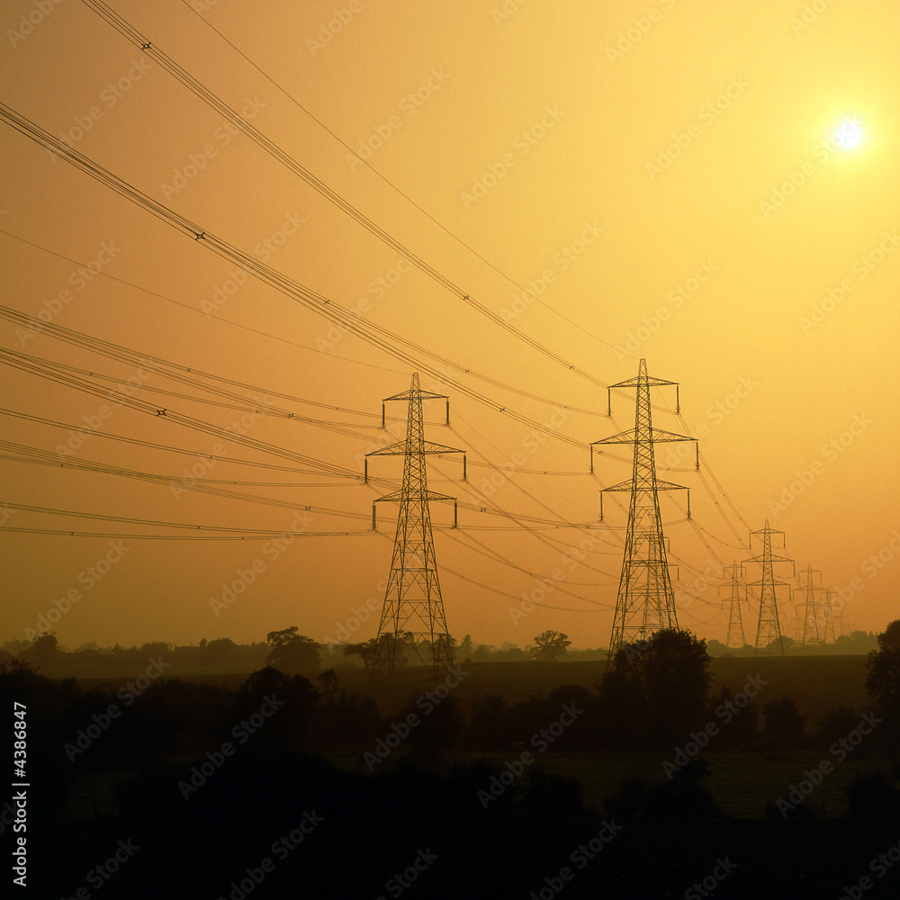 Fototapeta premium Electricity power lines and pylons in sunset