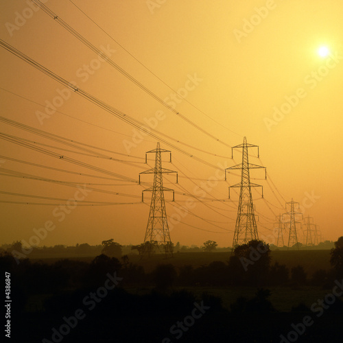 Electricity power lines and pylons in sunset