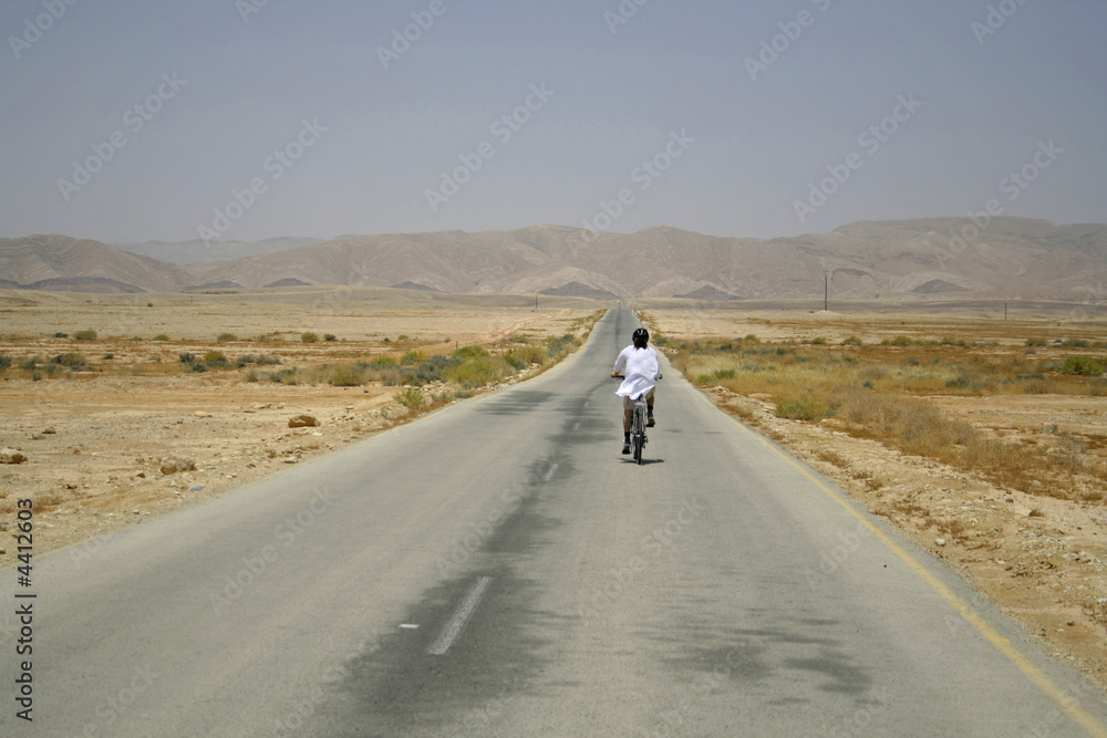 Fototapeta premium man cycling on sede boker desert road, israel