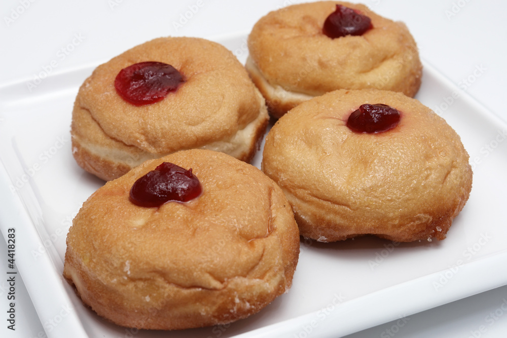 four jam donuts on white plate close up four jam donuts on white plate close up