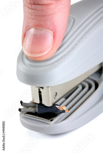 Miniature man squished in a stapler photo