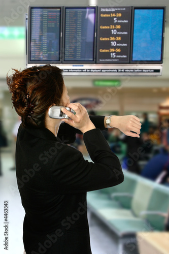 Asian businesswoman on her cellphone while looking at her watch,