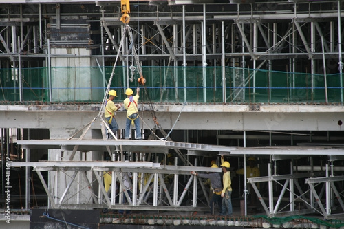 construction workers working at the edge of the building