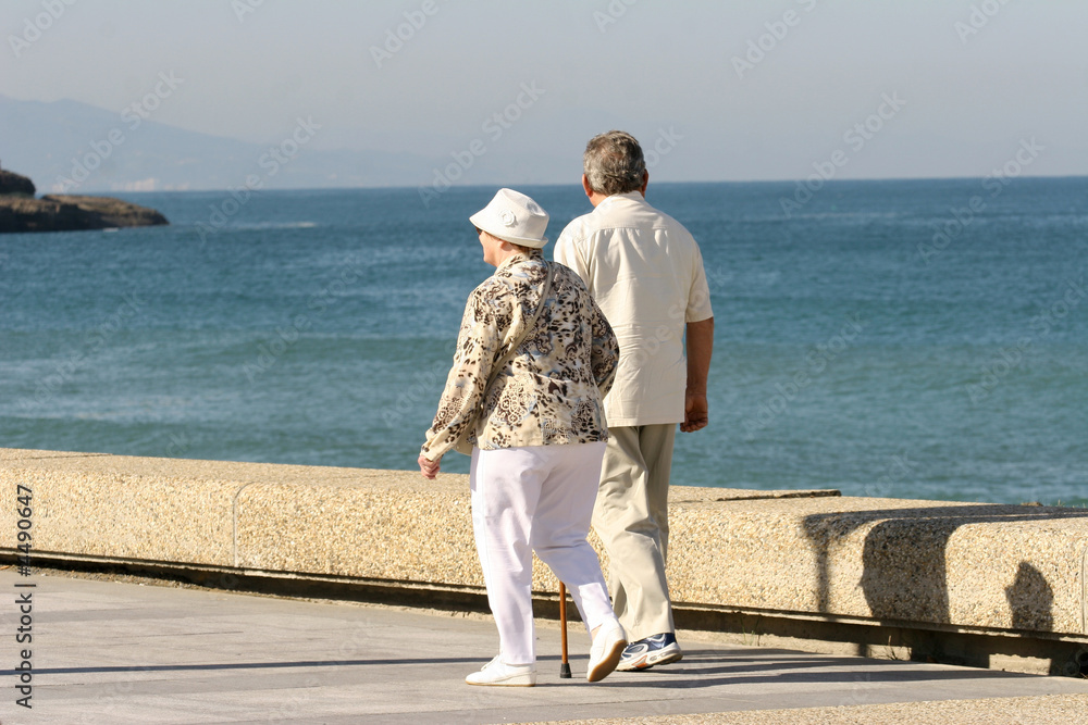 couple de retraités qui marchent en bord de plage