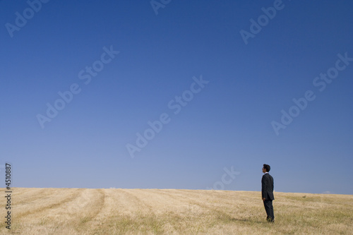 Businessman standing and thinking in the nature
